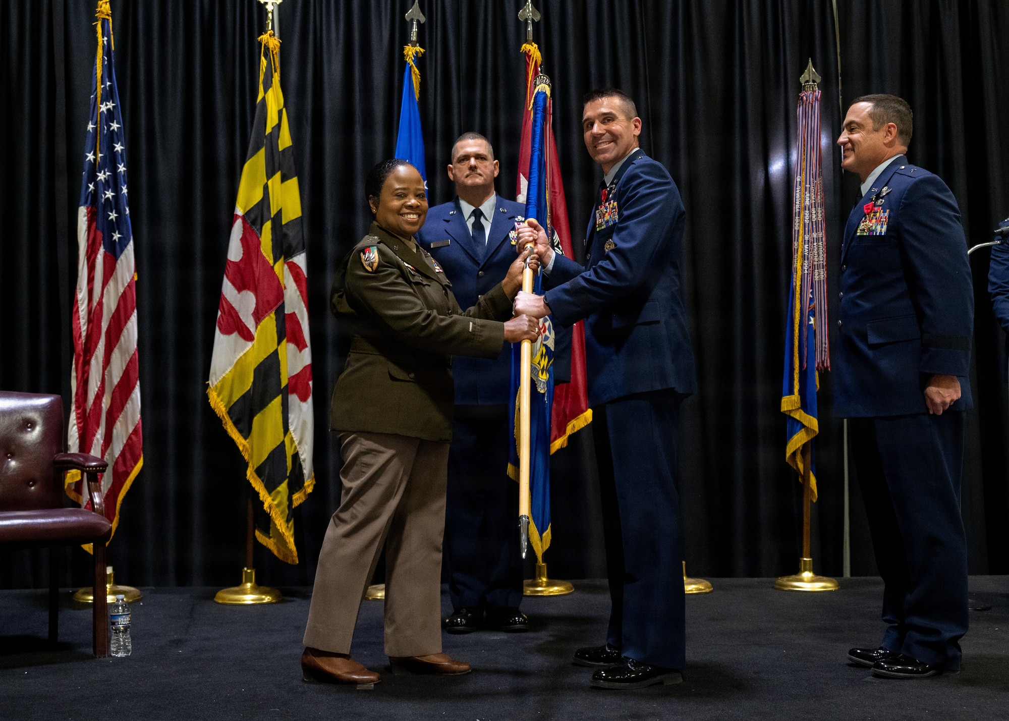 Maryland Army National Guard Maj. Gen. Janeen L. Birckhead, adjutant general of Maryland, passes the guidon to Maryland Air National Guard Brig. Gen. Richard Hunt, interim Maryland Air National Guard commander, during the Maryland Air National Guard change of command ceremony in which Maryland Air National Guard Brig. Gen. Drew E. Dougherty relinquished command to Hunt, December 7, 2025, at Warfield Air National Guard Base at Martin State Airport, Middle River, Maryland. Hunt has a long history in the Maryland Air National Guard, beginning his career as an enlisted member and working all the way up to wing commander and now interim assistant adjutant general. (U.S. Air National Guard photo by Airman 1st Class Sarah Hoover)
