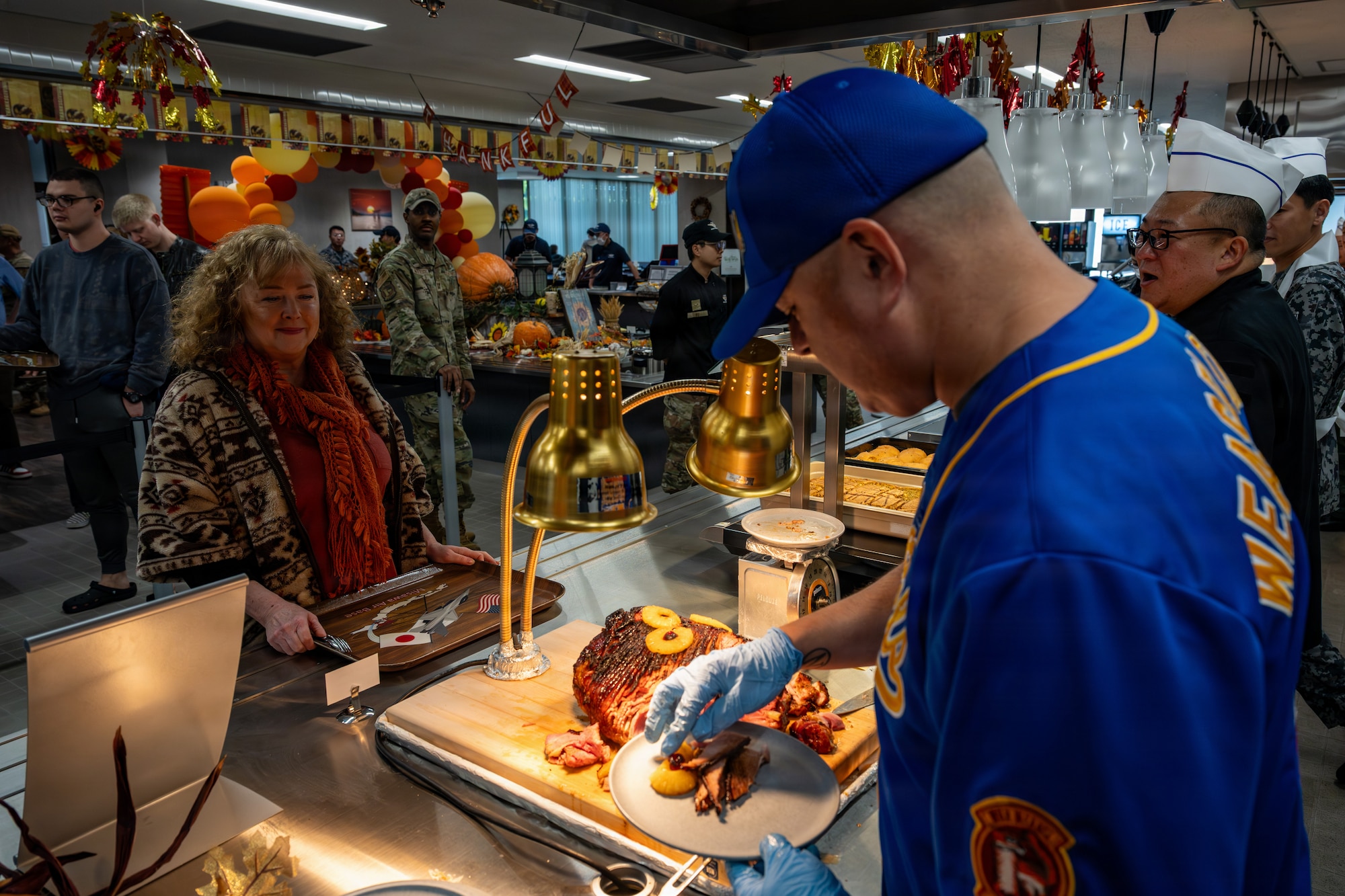 U.S. Air Force Chief Master Sgt. David Najera, 35th Fighter Wing command chief, serves food during the Thanksgiving Holiday Meal.