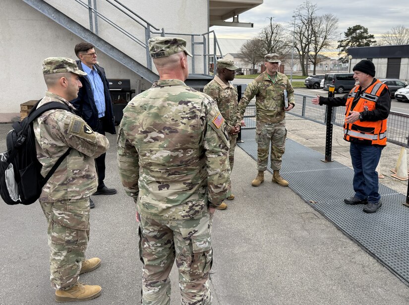 Arnoldo Montiel, the director of supply at the Coleman Army Prepositioned Stocks -2 worksite, briefs Col. Ernest Lane II, the commander of the 405th Army Field Support Brigade, and key personnel at worksite in Mannheim, Germany, Dec. 2. Lane and Command Sgt. Maj. Patrick Marrill, the brigade’s senior enlisted leader, visited Coleman to assess the ongoing transition of APS-2 maintenance operations between service providers. (Photo by Joe Scheff)
