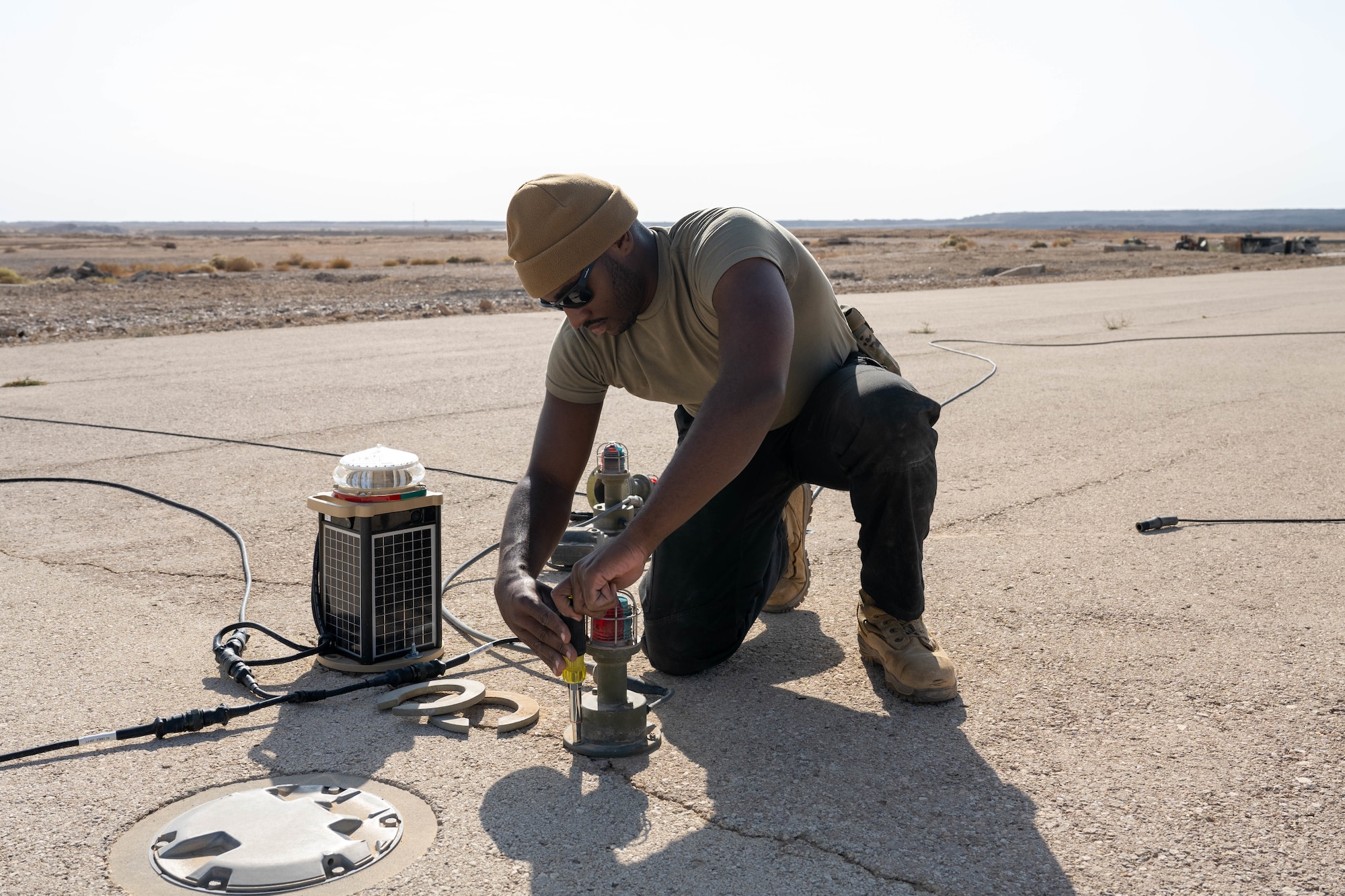 U.S. Air Force Senior Airman Gregory Curry, 332nd Expeditionary Civil Engineer Squadron electrical journeyman, removes an old lighting system from a runway in the U.S. Central Command area of responsibility, Nov. 19, 2025. The previous expeditionary airfield lighting system ran on a higher voltage and was more difficult for pilots and airfield drivers to see in hazy conditions. (U.S. Air Force photo by Senior Airman Kari Degraffenreed)