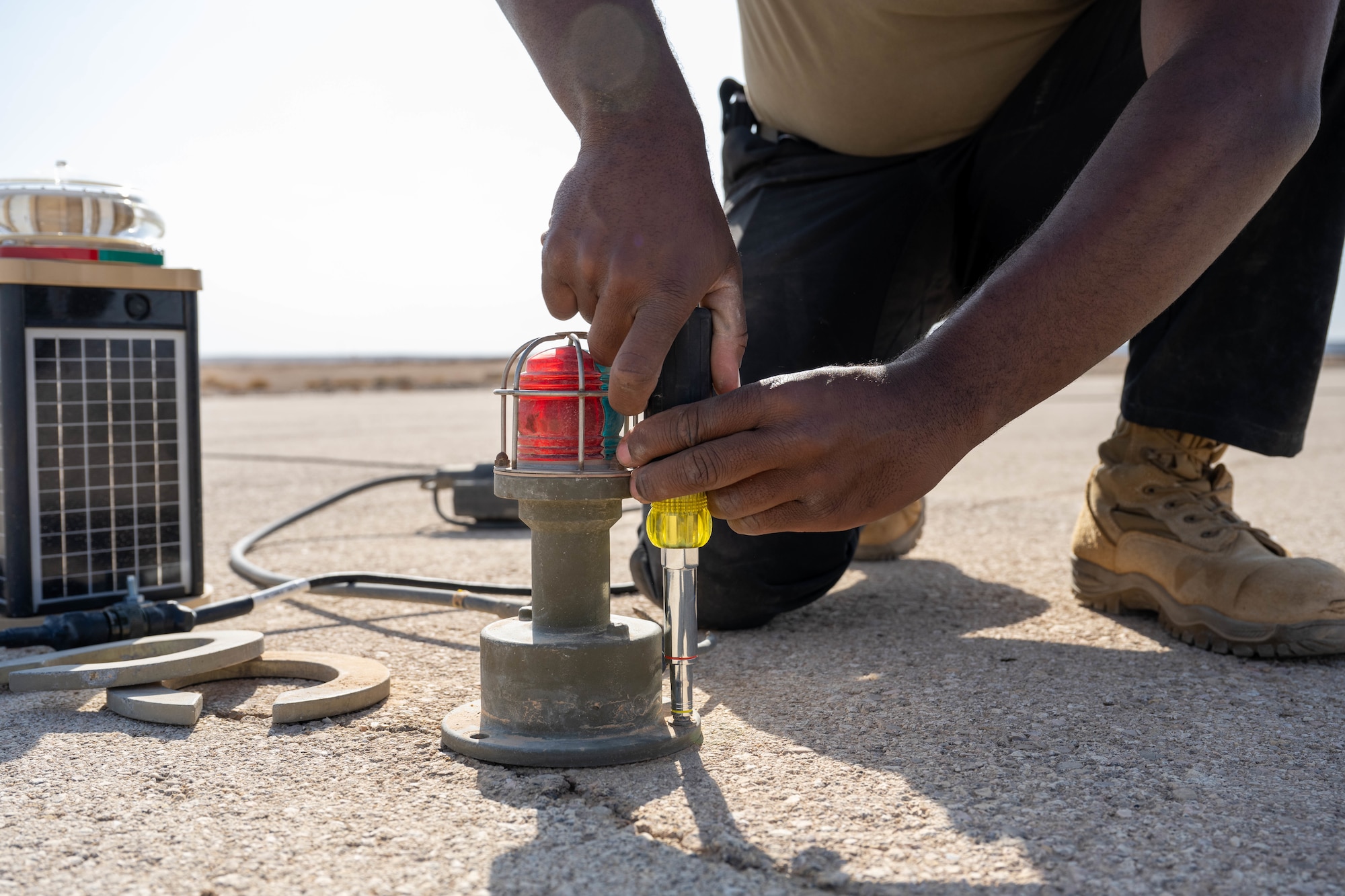U.S. Air Force Senior Airman Gregory Curry, 332nd Expeditionary Civil Engineer Squadron electrical journeyman, removes an old lighting system from a runway in the U.S. Central Command area of responsibility, Nov. 19, 2025. The previous expeditionary airfield lighting system ran on a higher voltage and became more difficult for pilots and airfield drivers to see in hazy conditions. (U.S. Air Force photo by Senior Airman Kari Degraffenreed)