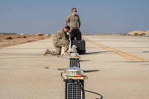 U.S. Air Force Senior Airman Treigh Boedigheimer, 332nd Expeditionary Civil Engineer Squadron electrical journeyman, left, and Senior Airman Logan Landon, 332nd ECES electrical journeyman, install upgraded lights on a runway in the U.S. Central Command area of responsibility, Nov. 19, 2025. Designed to cut through the region’s frequent dust and haze, the upgraded lights offer stronger, adjustable visibility for all airfield traffic. (U.S. Air Force photo by Senior Airman Kari Degraffenreed)