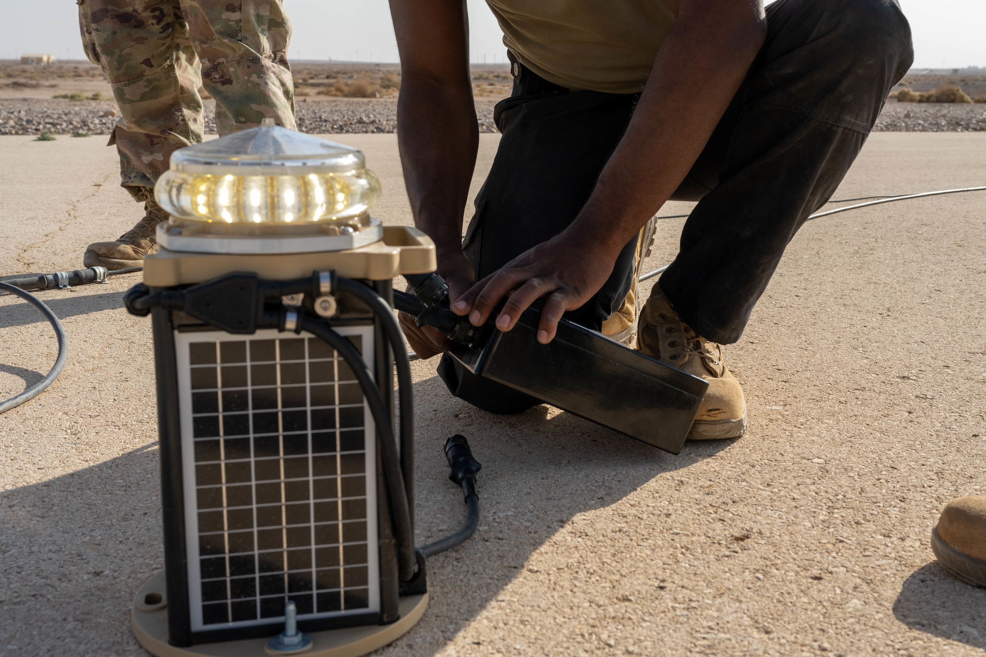 U.S. Air Force Senior Airman Gregory Curry, 332nd Expeditionary Civil Engineer Squadron electrical journeyman, removes an old lighting system from a runway in the U.S. Central Command area of responsibility, Nov. 19, 2025. The previous expeditionary airfield lighting system ran on a higher voltage and was more difficult for pilots and airfield drivers to see in hazy conditions. (U.S. Air Force photo by Senior Airman Kari Degraffenreed)