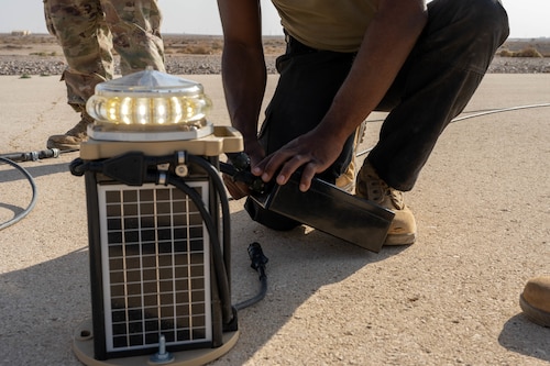 U.S. Air Force Senior Airman Gregory Curry, 332nd Expeditionary Civil Engineer Squadron electrical journeyman, removes an old lighting system from a runway in the U.S. Central Command area of responsibility, Nov. 19, 2025. The previous expeditionary airfield lighting system ran on a higher voltage and was more difficult for pilots and airfield drivers to see in hazy conditions. (U.S. Air Force photo by Senior Airman Kari Degraffenreed)