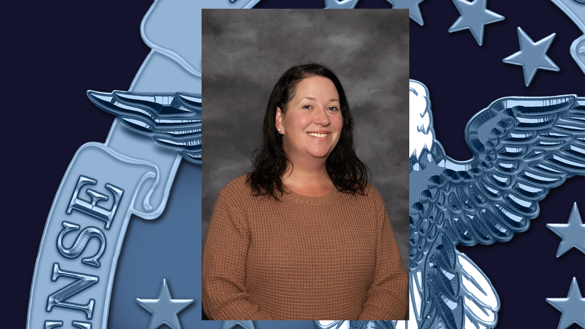 Headshot of woman with dark shoulder-length hair wearing tan shirt