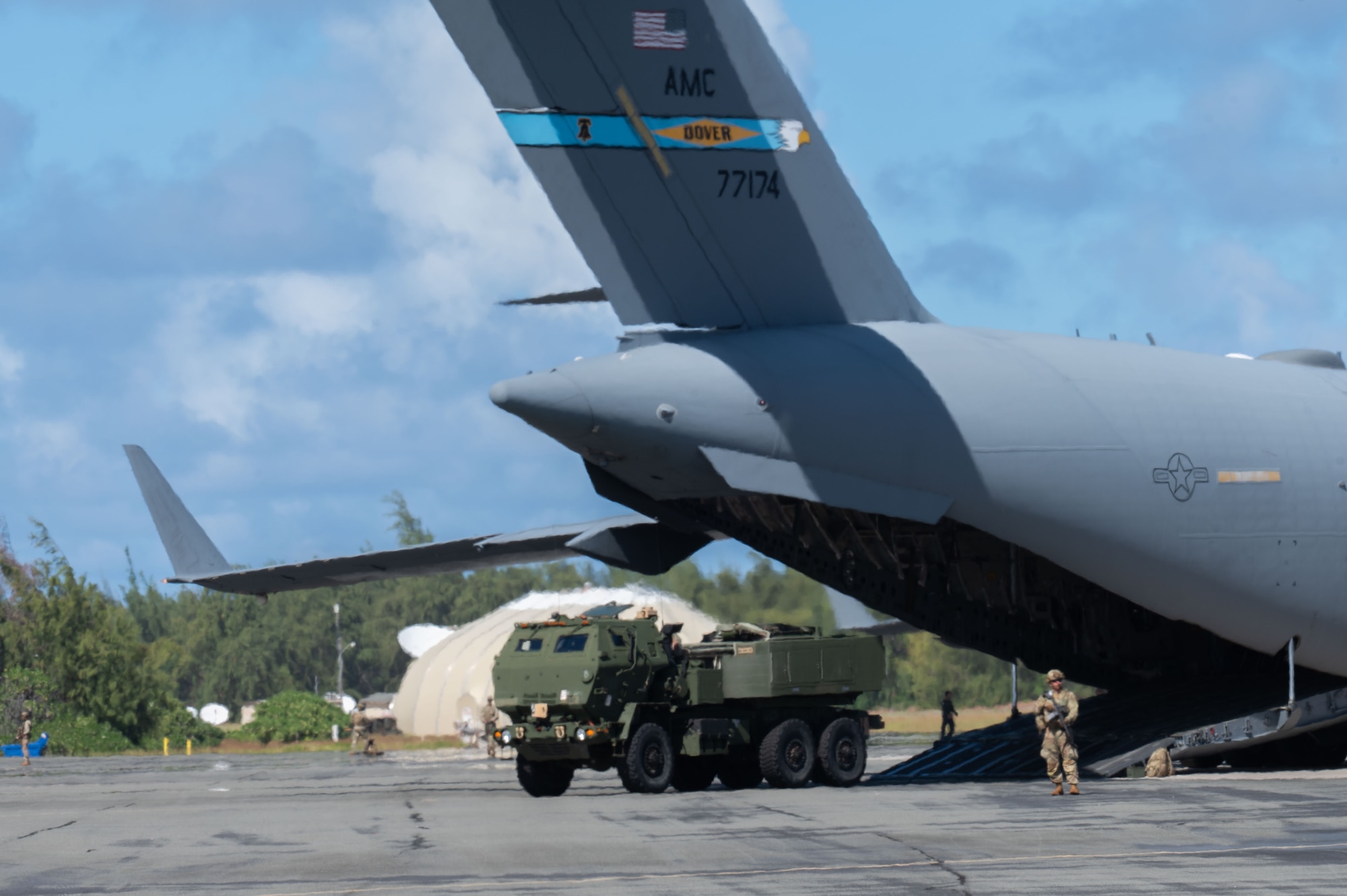 A U.S. Air Force C-17 Globemaster III from Dover Air Force Base, Delaware, executes a High Mobility Artillery Rocket System (HIMARS) Rapid Infiltration (HIRAIN) as part of the Joint Pacific Multinational Center 26-01 at Wake Island, Nov. 13, 2025. A HIRAIN is a vital joint military exercise designed to ensure the rapid deployment of HIMARS rocket systems to remote locations for live-fire missions and swift redeployments. (U.S. Air Force photo by Senior Airman Alondra Cristobal Hernandez)