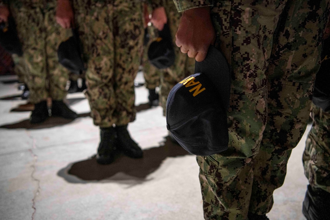 Sailors prepare for capping on USS Trayer’s pier at Recruit Training Command. Known as “Battle Stations,” this nine‑week crucible tests seamanship, firefighting, and emergency skills before graduation. Over 40,000 recruits train annually at Navy boot camp.