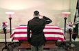 U.S. Army Master Sgt. William Harbeson, serving as a casualty assistance officer, or CAO, renders honors to Pfc. Lawrence R. Beard during funeral services in Westminster, Md. Beard, 27, died in a Japanese POW camp in November 1942. Beard’s remains were unidentified until earlier this year and CAOs accompanied him home for burial.