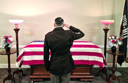 U.S. Army Master Sgt. William Harbeson, serving as a casualty assistance officer, or CAO, renders honors to Pfc. Lawrence R. Beard during funeral services in Westminster, Md. Beard, 27, died in a Japanese POW camp in November 1942. Beard’s remains were unidentified until earlier this year and CAOs accompanied him home for burial.