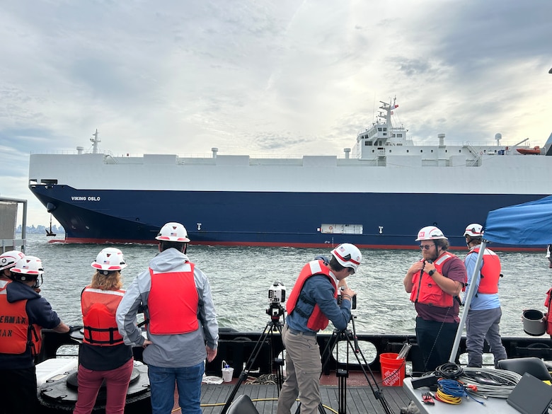 The crew with representatives from ERDC and the New York District face the vessel Viking Oslo while preparing for the anchor testing.