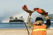 A U.S. Sailor assigned to the Iwo Jima Amphibious Ready group signals a landing craft, air cushion onto a beach landing zone in Ponce, Puerto Rico, Nov. 29, 2025. U.S. military forces are deployed to the Caribbean in support of the U.S. Southern Command mission, Department of War-directed operations, and the president's priorities to disrupt illicit drug trafficking and protect the homeland. (U.S. Marine Corps photo)