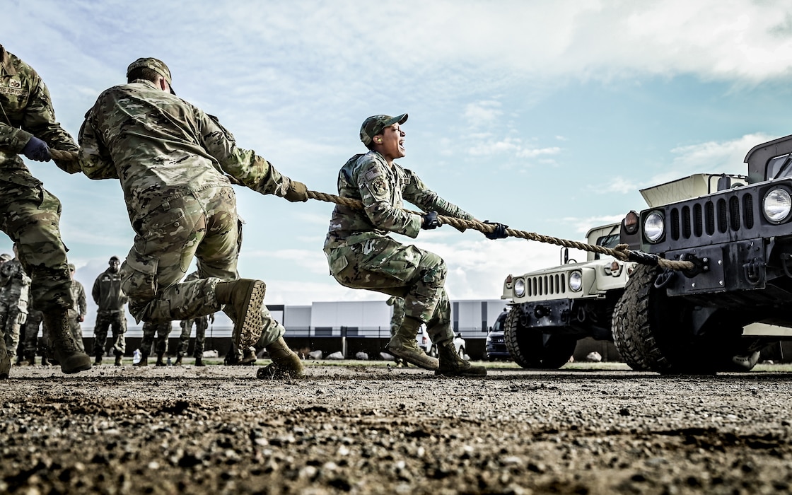 U.S. Air Force Senior Airman Caliya Cortner, 56th Civil Engineer Squadron engineering apprentice, strains alongside her team to pull a Humvee during the Prime Base Engineer Emergency Force readiness challenge