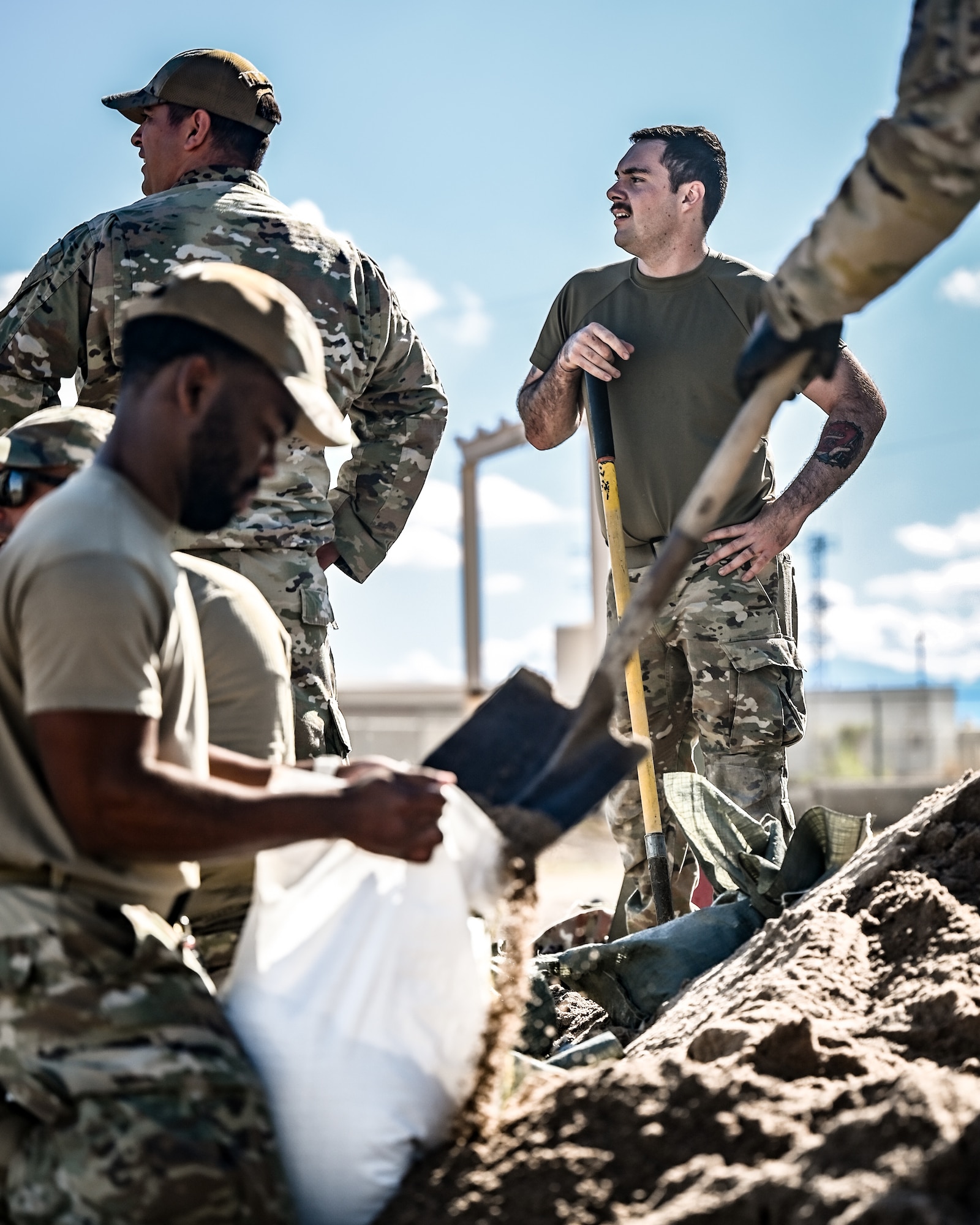 U.S. Air Force Airman 1st Class Jason Linsenman (right), 56th Civil Engineer Squadron structural apprentice, works alongside his team to fill sandbags, constructing a defensive firing post as part of the Prime Base Engineer Emergency Force readiness challenge