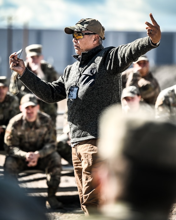 Akoni Mirafuentes, 56th Operations Support Squadron aircrew flight equipment continuation instructor, demonstrates the use of a signal mirror to communicate with overhead aircraft during the Prime Base Engineer Emergency Force readiness challenge