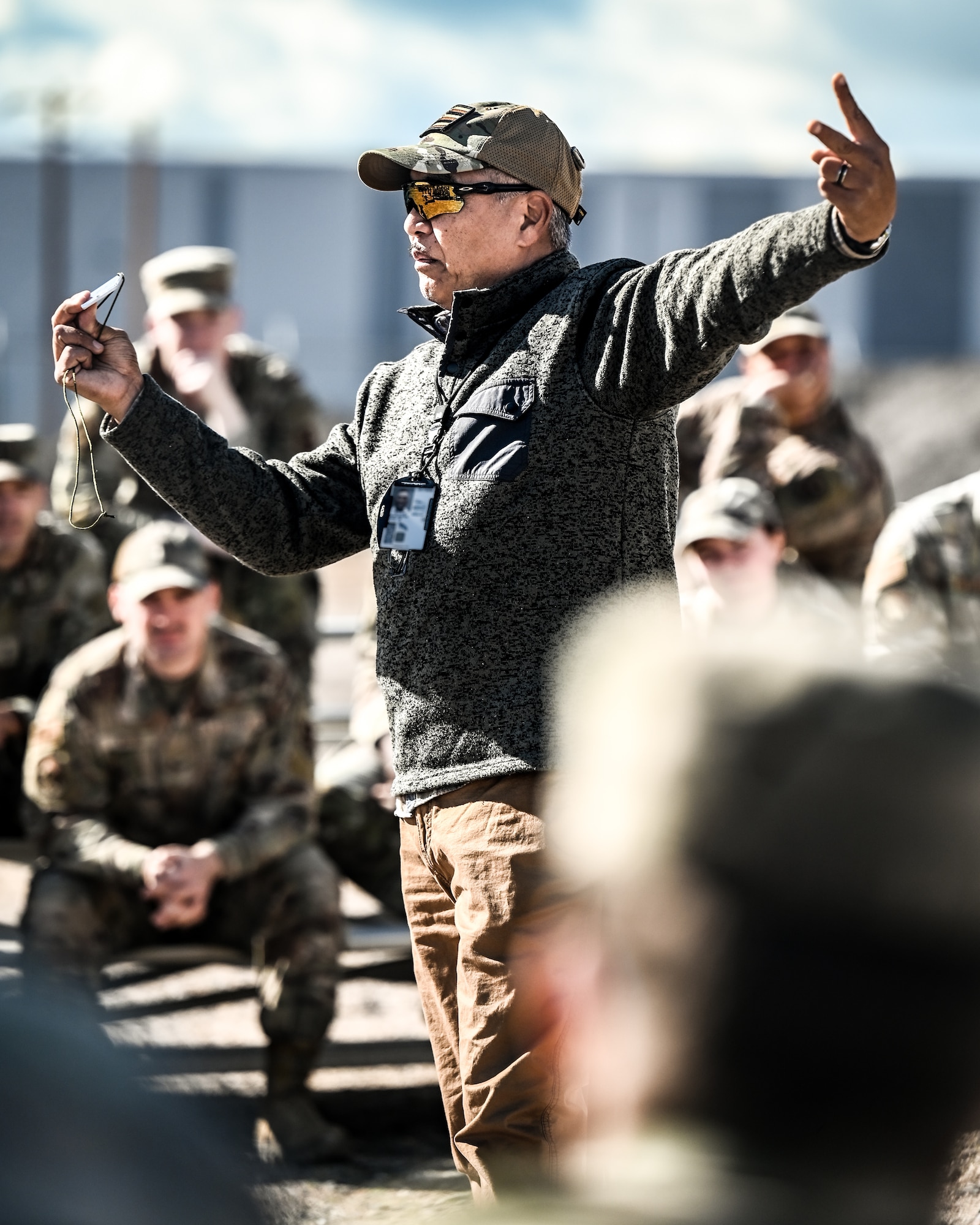 Akoni Mirafuentes, 56th Operations Support Squadron aircrew flight equipment continuation instructor, demonstrates the use of a signal mirror to communicate with overhead aircraft during the Prime Base Engineer Emergency Force readiness challenge