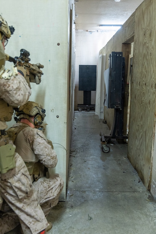 Reconnaissance Marines with the 24th Marine Expeditionary Unit (MEU), take cover as they are about to breach a door with explosives as part of Close Quarters Tactics training on Stone Bay, Camp Lejeune, North Carolina, on December 03, 2025. The 24th MEU is a Marine Air-Ground Task Force ready to answer the nation's call in any clime and place.(U.S. Marine Corps photo by Cpl. Daniel R. Garcia)