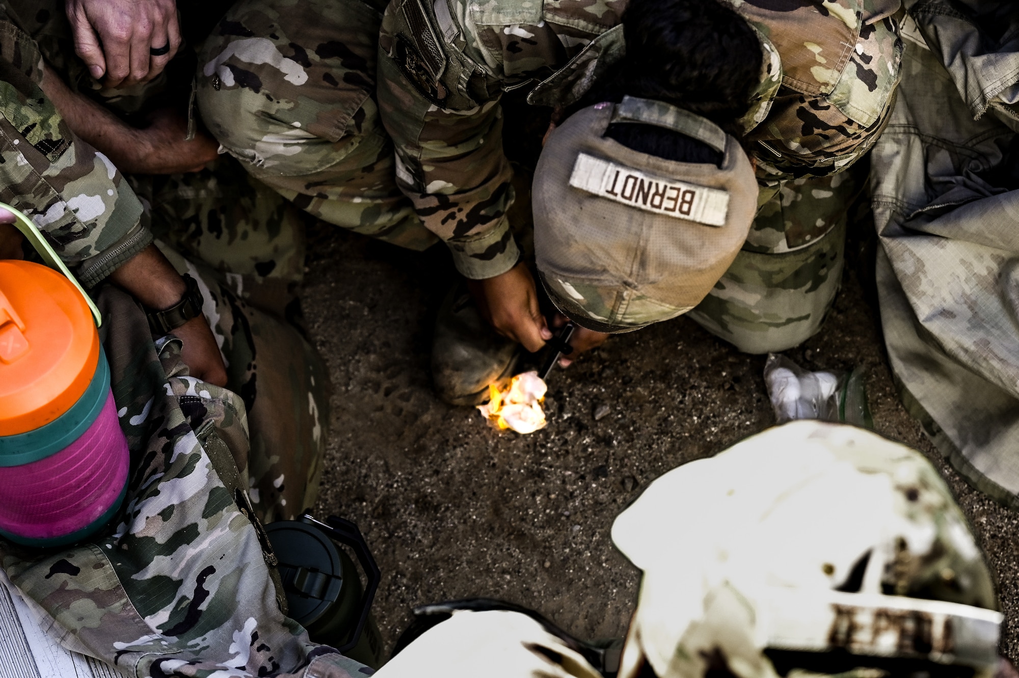 U.S. Air Force Airman 1st Class Alexis Berndt, 56th Civil Engineer Squadron electrical systems specialist, strikes flint and steel to ignite a fire during the Prime Base Engineer Emergency Force readiness challenge