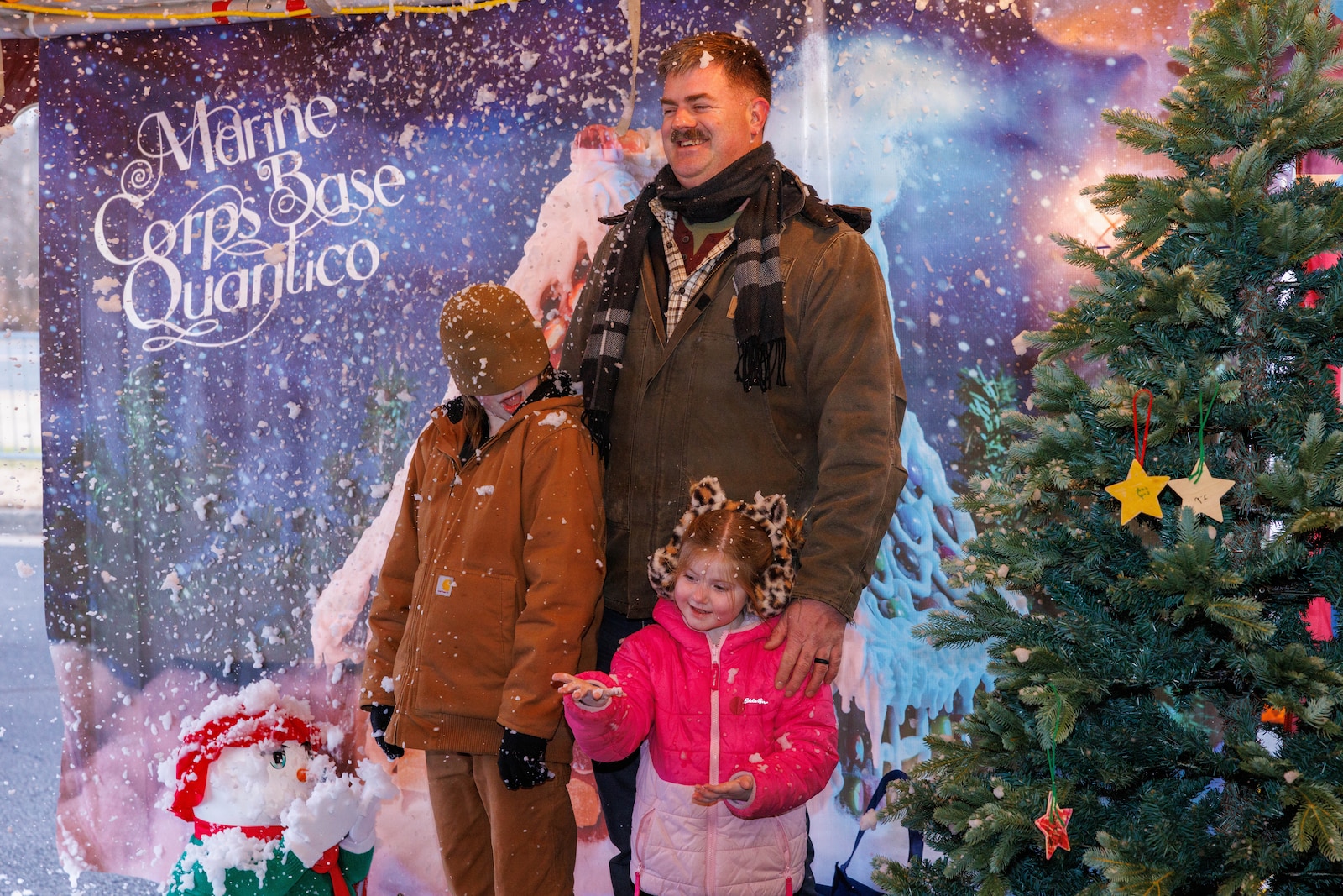 A family poses for a photo during the holiday festival at Marine Corps Base Quantico, Dec 4, 2025. The festival featured holiday crafts, a seasonal market with local vendors, food trucks, ice skating, snowball fights and photos with Santa. (U.S. Marine Corps photo by Lance Cpl. Federico Marquez)