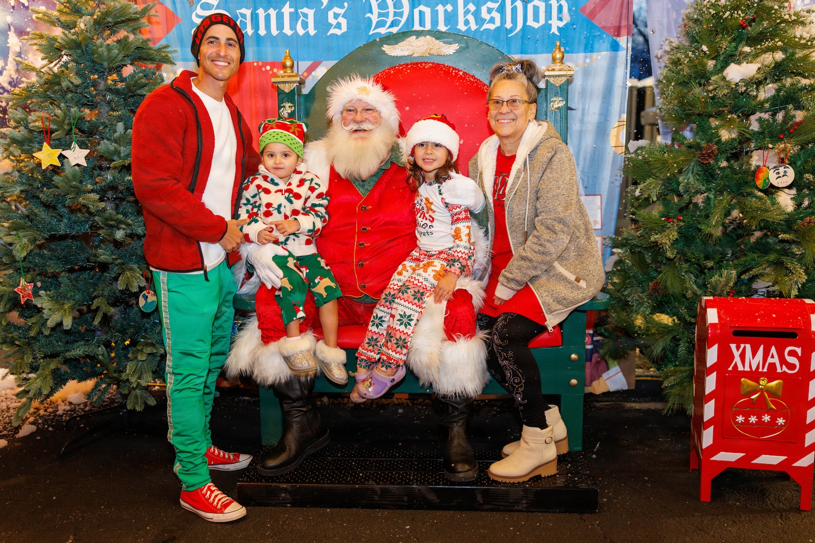 Santa takes a photo with a family during his visit to the holiday festival at Marine Corps Base Quantico, Dec. 4, 2025. The festival featured holiday crafts, a seasonal market with local vendors, food trucks, ice skating, snowball fights and photos with Santa. (U.S. Marine Corps photo by Lance Cpl. Federico Marquez)