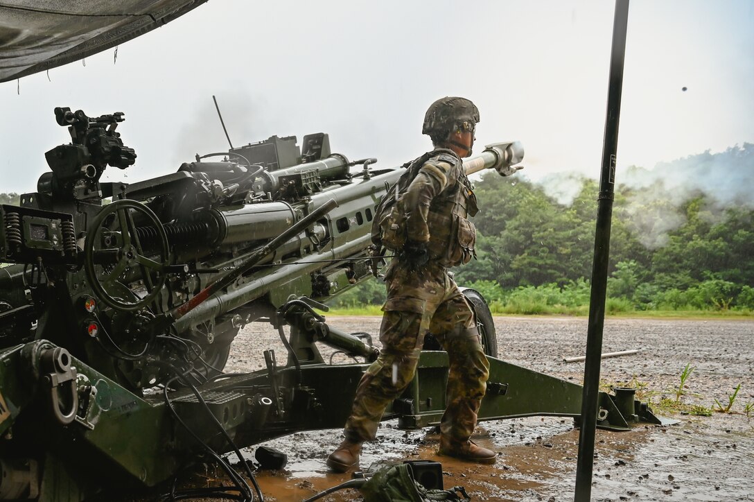 A round can be seen as a Soldier from 2-12 FA fires an M777 howitzer during Table VI qualification at Rodriguez Live Fire Complex, South Korea, Aug. 13, 2025. The live-fire event tested crews on accuracy, speed, and communication under realistic conditions.
