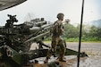 A round can be seen as a Soldier from 2-12 FA fires an M777 howitzer during Table VI qualification at Rodriguez Live Fire Complex, South Korea, Aug. 13, 2025. The live-fire event tested crews on accuracy, speed, and communication under realistic conditions.