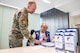 Master Sgt. Anthony Eberly, 59th Medical Wing volunteer services coordinator, reviews information desk procedures with volunteer Sharon Disler at the Wilford Hall Ambulatory Surgical Center, Joint Base San Antonio–Lackland, Texas, Dec. 4, 2025.