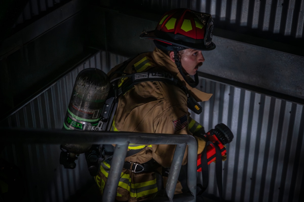 Firefighter climbs stairs during training exercise