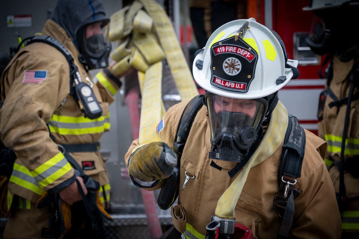 Firefighter pulls a hose during a live-fire