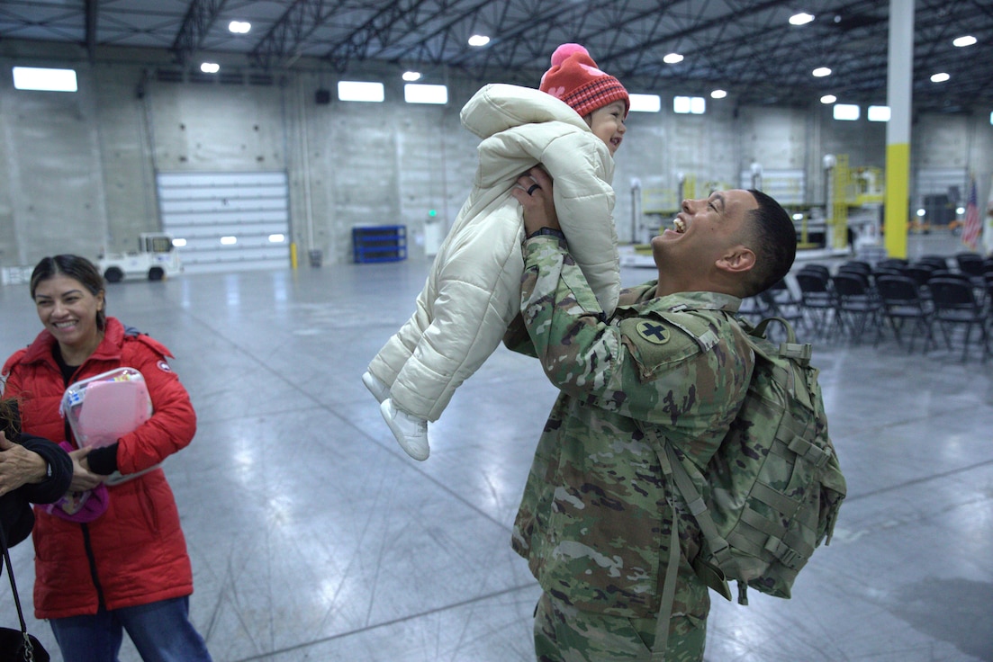 U.S. Army Pfc. Adrian Hernandez holds his 1-year-old daughter, Catalina.