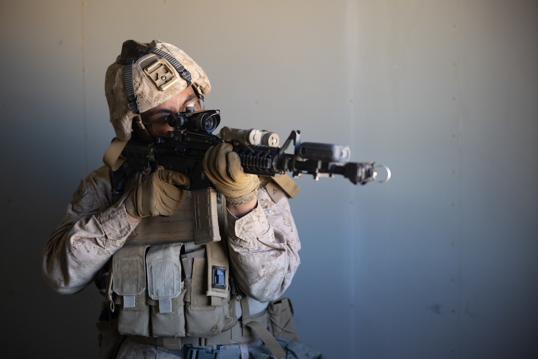 U.S. Marine Corps Lance Cpl. Markmarvyn Jader, Las Vegas, Nevada native, machine gunner with 2nd Battalion, 23rd Marine Regiment, 4th Marine Division, observes enemy movements during Adversary Force Exercise 1-25 at Range 220, Marine Corps Air-Ground Combat Center, Twentynine Palms, California, Feb. 8, 2025. Live Virtual Constructive Training with gear such as the Marine Corps Tactical Instrumentation System, integrates real-time data, virtual environments, and live forces to enhance training realism, improve decision-making, and ensure readiness across all domains by providing accurate feedback and fostering seamless coordination between multiple training platforms. AFX challenges Marines to face a thinking, adaptive enemy in a force-on-force, wargame to test decision-making and ensure we remain ready to outmaneuver and overcome any adversary. (U.S. Marine Corps photo by Pfc. Alexander Mantai)