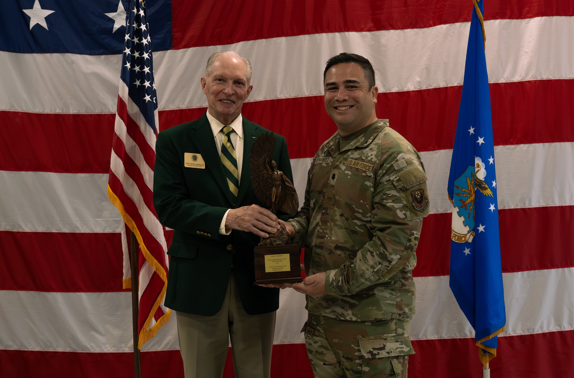 Retired U.S. Navy Capt. Mike Denkler, Order of Daedalians director, left, presents Lt. Col. Garrett Hernandez, 1st Special Operations Logistics Readiness Squadron commander, with the 2024 Daedalian Maj. Gen. Warren R. Carter Logistics Effectiveness award at Hurlburt Field, Florida, Nov. 24, 2025.