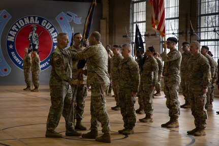 Lt. Col. Andrew V. Salmo, outgoing commander of the 1st Battalion, 178th Infantry Regiment, passes the battalion guidon to Col. Michael Kowalski, commander of the 33rd Infantry Brigade Combat Team.