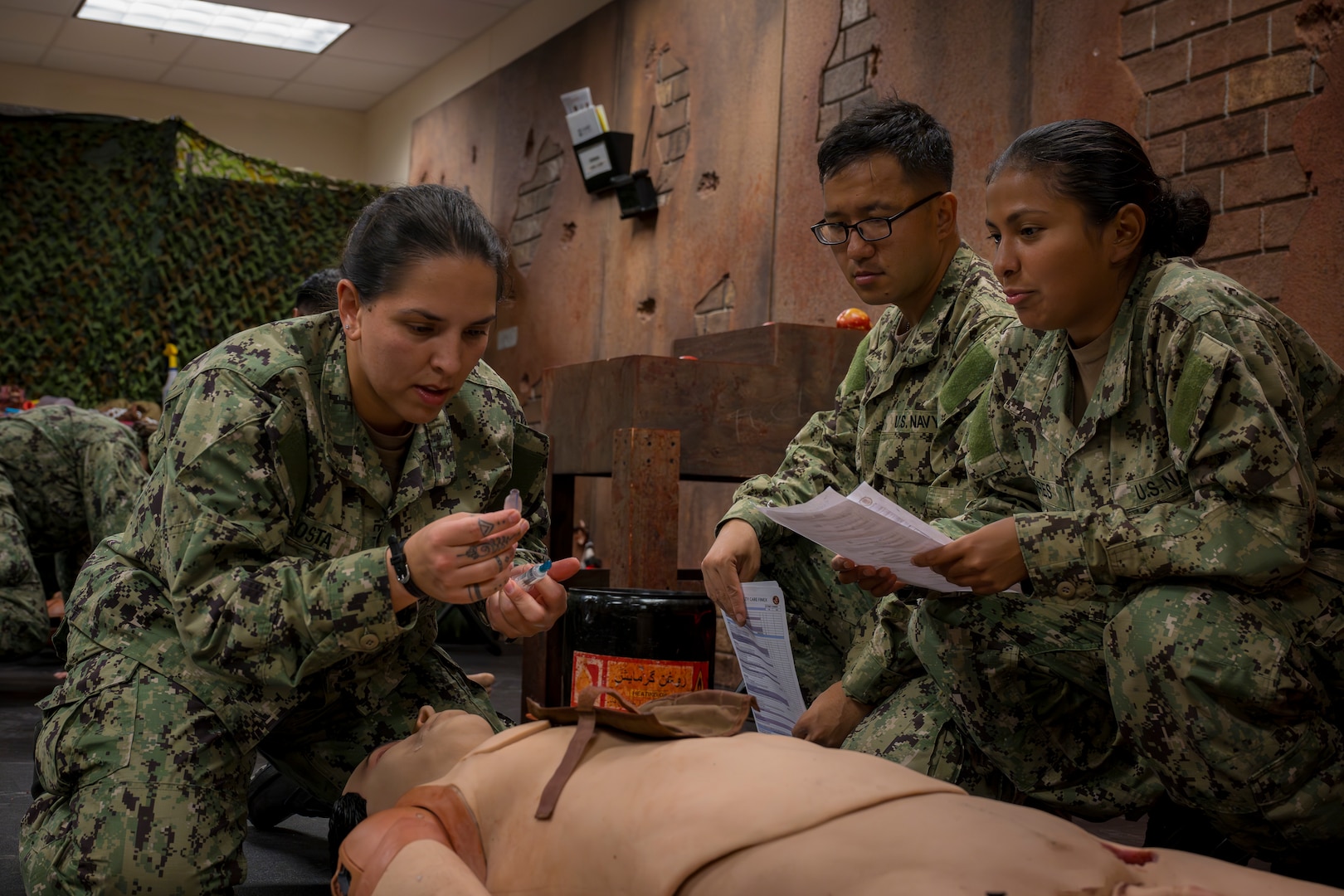 Hospitalman Nicole Acostacabrera, left, a Hospital Corpsman Basic student at the Navy Medicine Training Support Command, wraps up her final training evolution (FINEX) at Joint Base San Antonio, Texas, Sept. 09, 2025. At the FINEX, HCB students put their combat lifesaver skills to the test, mastering crucial battlefield medical techniques like tourniquet application, airway management and medication administration. Successfully completing this final assessment is the last step toward graduation and on to the fleet where they will play a vital role in the well-being of U.S. Navy and U.S. Marine Corps service members and their families. (U.S. Navy photo by Malcolm McClendon).