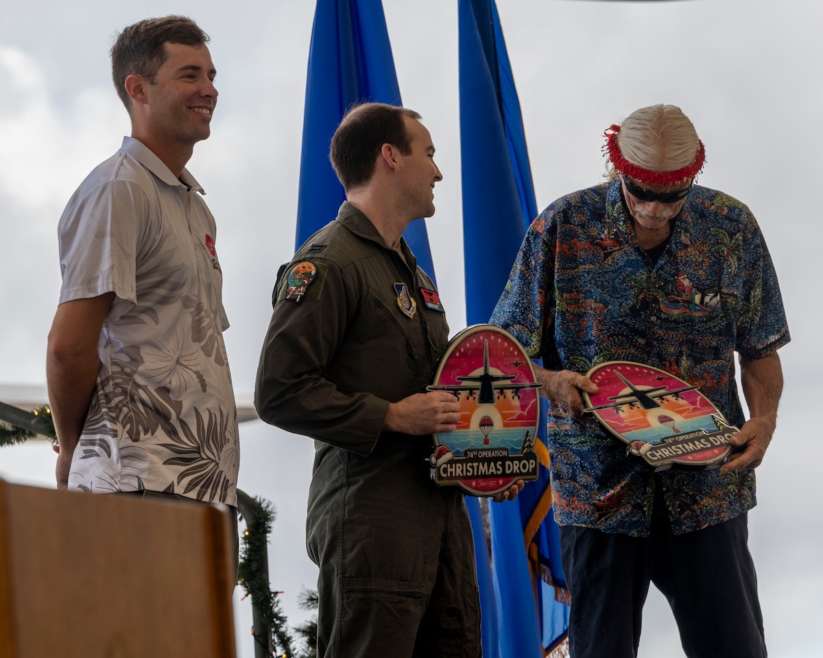 A military member and a civilian hold gifts.