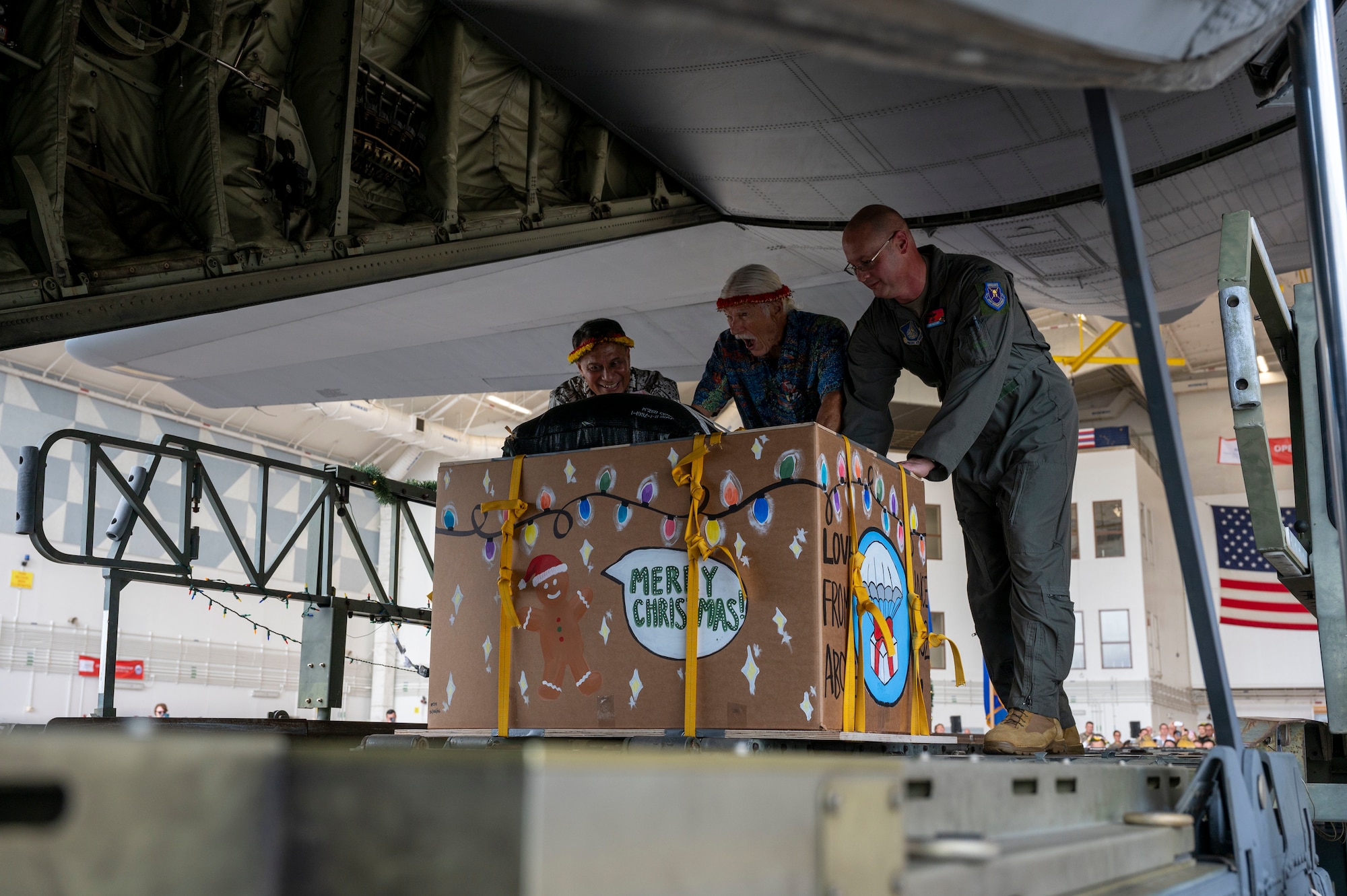 Three people push a decorated box.