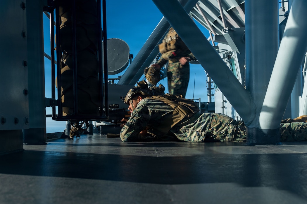 U.S. Marines with Battalion Landing Team 3/5, 11th Marine Expeditionary Unit, post security behind a .50-caliber special applications scoped rifle during a simulated strait transit on Wasp-class amphibious assault ship USS Boxer (LHD 4) in the Pacific Ocean, Dec. 7, 2025.