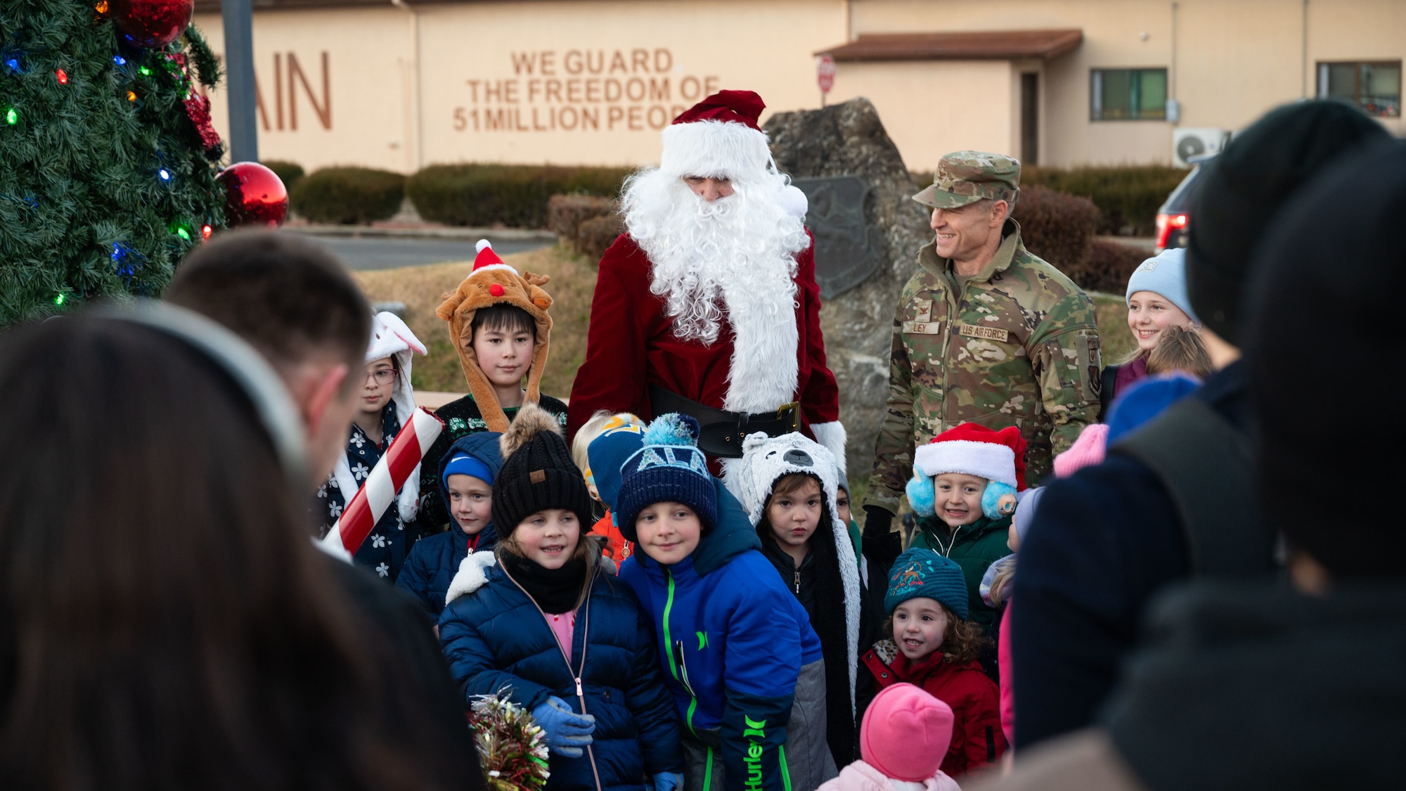 U.S. Air Force Col. Ryan Ley, 51st Fighter Wing commander, center right, takes photos with Santa Claus and children at Osan Air Base, Republic of Korea, Dec. 5, 2025. Activities throughout the event helped foster camaraderie and reinforced the sense of community shared across the installation. (U.S. Air Force photo by Senior Airman Rome Bowermaster)