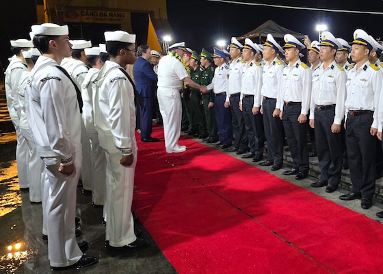 Capt. Stephen Henz, commanding officer of the Ticonderoga-class guided-missile cruiser USS Robert Smalls (CG 62), center, and Ambassador Marc E. Knapper, the U.S. Ambassador to Vietnam, center-left, shake hands with members of the Vietnam People's Navy during an arrival ceremony for a port visit to Da Nang, Vietnam, Dec. 8, 2025.