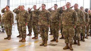 Members of the 133rd Combat Training Squadron offer their first salute to new commander Lt. Col. Kevin Taylor during an activation ceremony Dec. 6, 2025, at the 132rd Wing in Des Moines, Iowa.