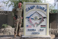 U.S. Air Force Chief Master Sgt. Frank Rawls stands in front of the Camp Simba sign for a photo while being deployed to Operation OCTAVE SHIELD at Manda Bay, Kenya, March 22, 2022.