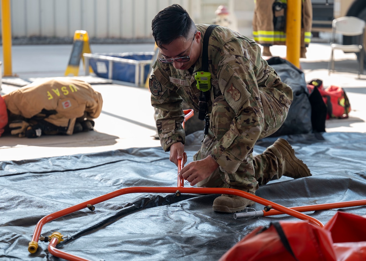 A man in a military uniform assembles a metal hoop.