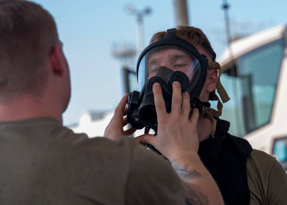 A man removes a mask from another man's face.