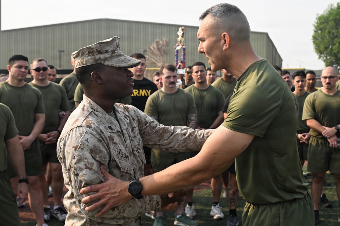 U.S. Marine Corps Brig. Gen. Stephen J. Lightfoot, commanding general of Naval Amphibious Force, Task Force 51/5th Marine Expeditionary Brigade (TF 51/5), congratulates Sgt. Tafari D. Galloway, an administrative clerk with TF 51/5, on returning from his meritorious promotion at the Pentagon for his efforts during the recent 12-day regional conflict, at Naval Support Activity, Bahrain on Nov. 13, 2025. TF 51/5 participated in a unit-wide physical training session to commemorate the 250th anniversary of the United States Marine Corps, fostering esprit de corps and camaraderie. (U.S. Navy photo by Mass Communication Specialist 2nd Class Kade Bise)