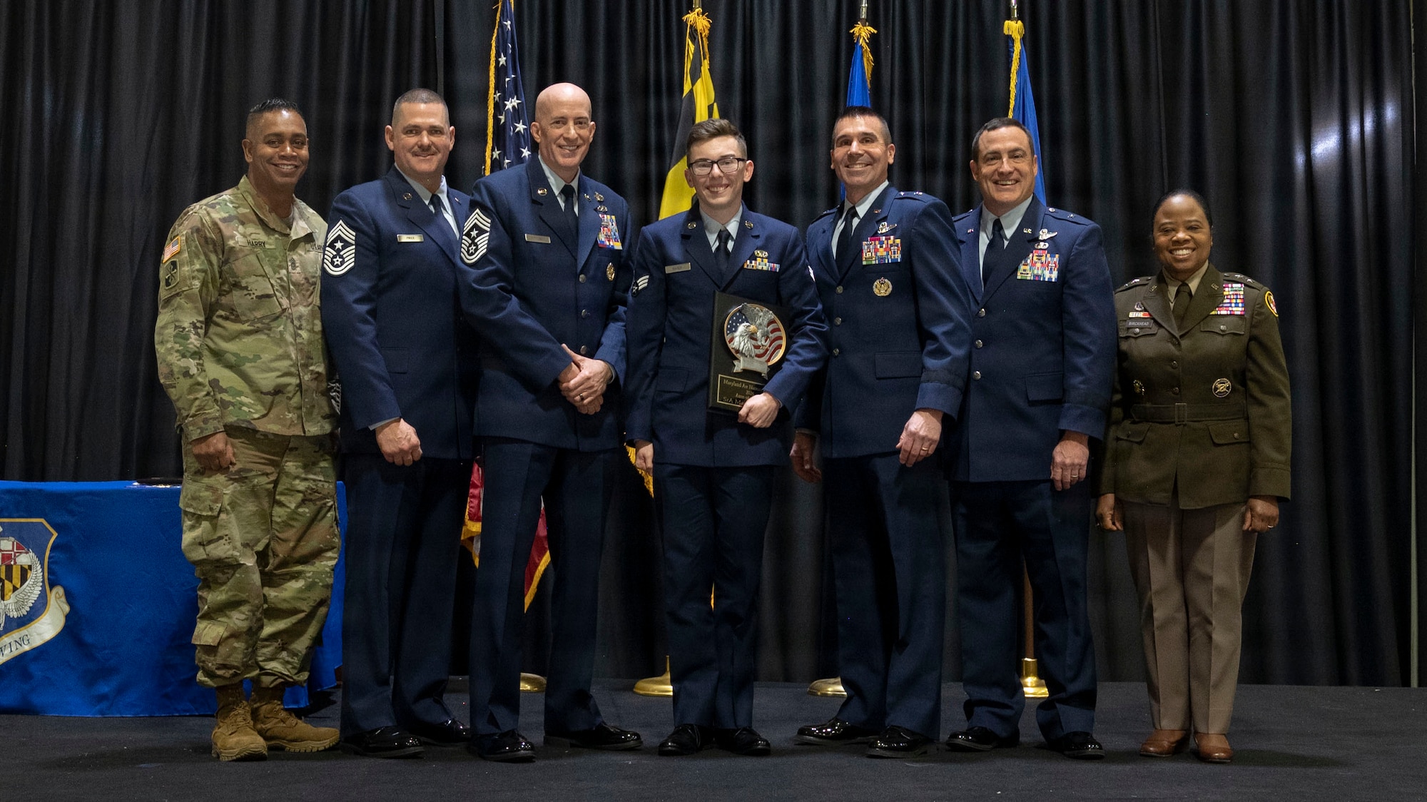 Maryland Air National Guard Senior Airman Matthew Baker, 175th Operations Support Squadron, airman of the year, receives a plaque during the 175th’s Wing Airman Recognition Ceremony at Warfield Air National Guard Base at Martin State Airport, Maryland, December 7, 2025. The annual event honors the wonderful achievements of the Maryland National Guard and recognizes the wing’s outstanding airmen of the year. (U.S. Air National Guard Photo by Staff Sgt. Alexandra Huettner)