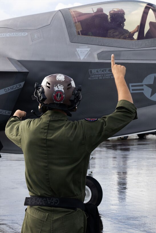 A U.S. Marine Corps plane captain with Marine Fighter Attack Squadron (VMFA) 225, U.S. Marine Corps Forces, South, signals to a U.S. Marine Corps F-35B Lightning II pilot with  VMFA-225 at Jose Aponte de la Torre Airport in Ceiba, Puerto Rico, Nov. 26, 2025. U.S. military forces are deployed to the Caribbean in support of the U.S. Southern Command mission, Department of War-directed operations, and the president’s priorities to disrupt illicit drug trafficking and protect the homeland. (U.S. Marine Corps photo)