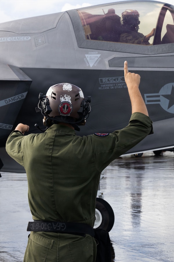 A U.S. Marine Corps plane captain with Marine Fighter Attack Squadron (VMFA) 225, U.S. Marine Corps Forces, South, signals to a U.S. Marine Corps F-35B Lightning II pilot with  VMFA-225 at Jose Aponte de la Torre Airport in Ceiba, Puerto Rico, Nov. 26, 2025. U.S. military forces are deployed to the Caribbean in support of the U.S. Southern Command mission, Department of War-directed operations, and the president’s priorities to disrupt illicit drug trafficking and protect the homeland. (U.S. Marine Corps photo)