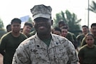 U.S. Marine Corps Sgt. Tafari D. Galloway, an administrative clerk with Naval Amphibious Force, Task Force 51/5th Marine Expeditionary Brigade (TF 51/5), celebrates with Marines, Sailors, and Soldiers of the unit the behind him during a physical training event on Nov. 13, 2025 as he is recognized in front of others for his efforts during a recent 12-day regional conflict at Naval Support Activity, Bahrain. TF 51/5 participated in the unit-wide physical training session to commemorate the 250th anniversary of the United States Marine Corps, fostering esprit de corps and camaraderie. (U.S. Navy photo by Mass Communication Specialist 2nd Class Kade Bise)