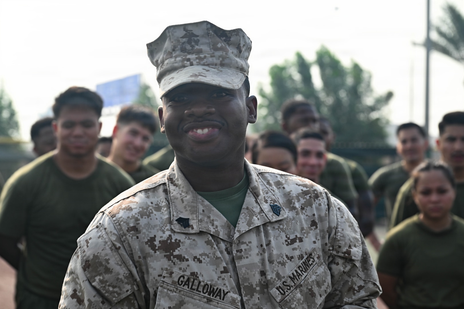 U.S. Marine Corps Sgt. Tafari D. Galloway, an administrative clerk with Naval Amphibious Force, Task Force 51/5th Marine Expeditionary Brigade (TF 51/5), celebrates with Marines, Sailors, and Soldiers of the unit the behind him during a physical training event on Nov. 13, 2025 as he is recognized in front of others for his efforts during a recent 12-day regional conflict at Naval Support Activity, Bahrain. TF 51/5 participated in the unit-wide physical training session to commemorate the 250th anniversary of the United States Marine Corps, fostering esprit de corps and camaraderie. (U.S. Navy photo by Mass Communication Specialist 2nd Class Kade Bise)