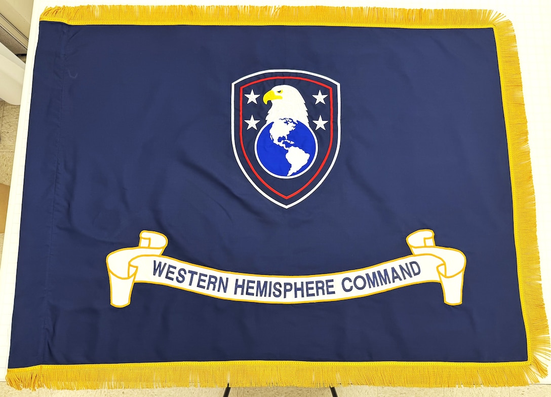 a blue flag with an eagle, globe and written scroll, with gold fringe