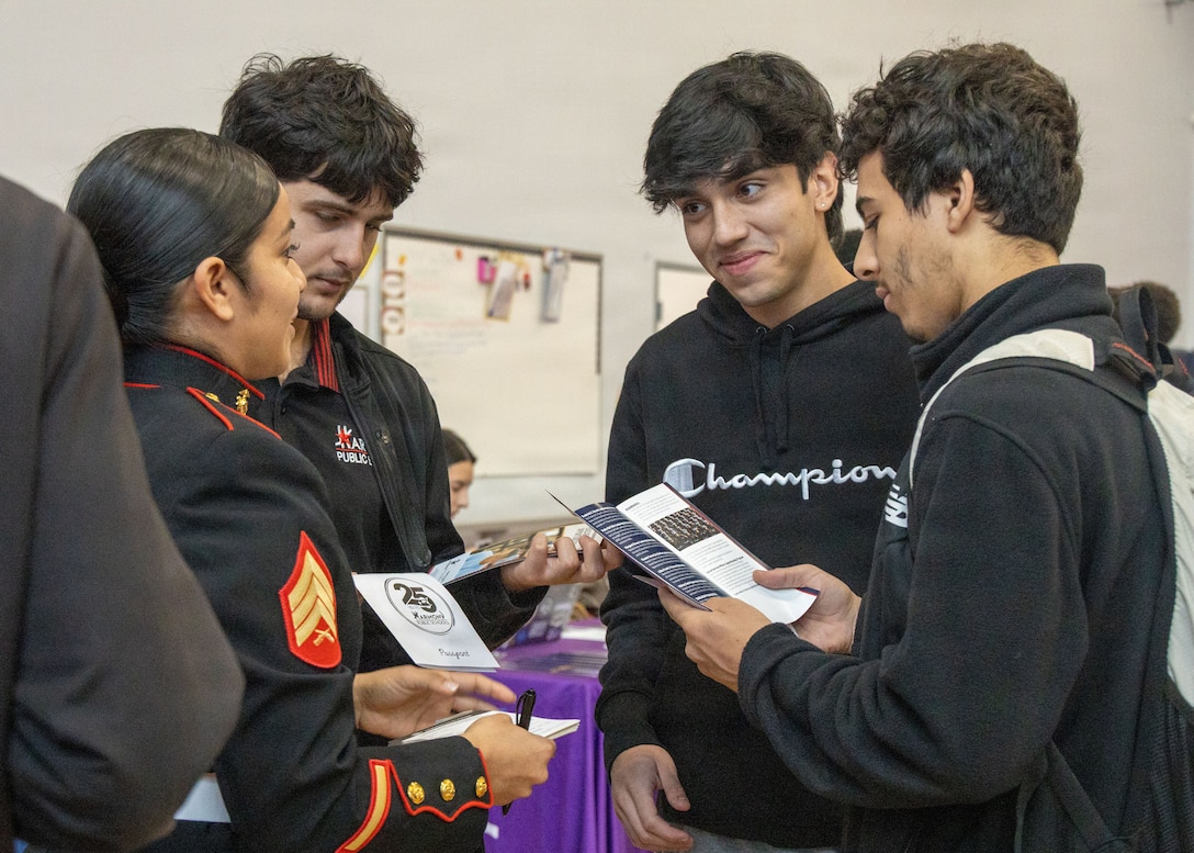 U.S. Marine Sgt. Cynthia Baca, a recruiter with Recruiting Sub-Station Austin North, Recruiting Station Austin, talks with students from Harmony School of Endeavor during a career fair at Harmony School of Endeavor in Austin, Texas, Dec. 5, 2025. The career fair allowed students to gain hands-on experience in a professional setting, practicing formal greetings, networking, and professional conversation for the first time. (U.S. Marine Corps photo by Sgt. Jose D. Cruz)